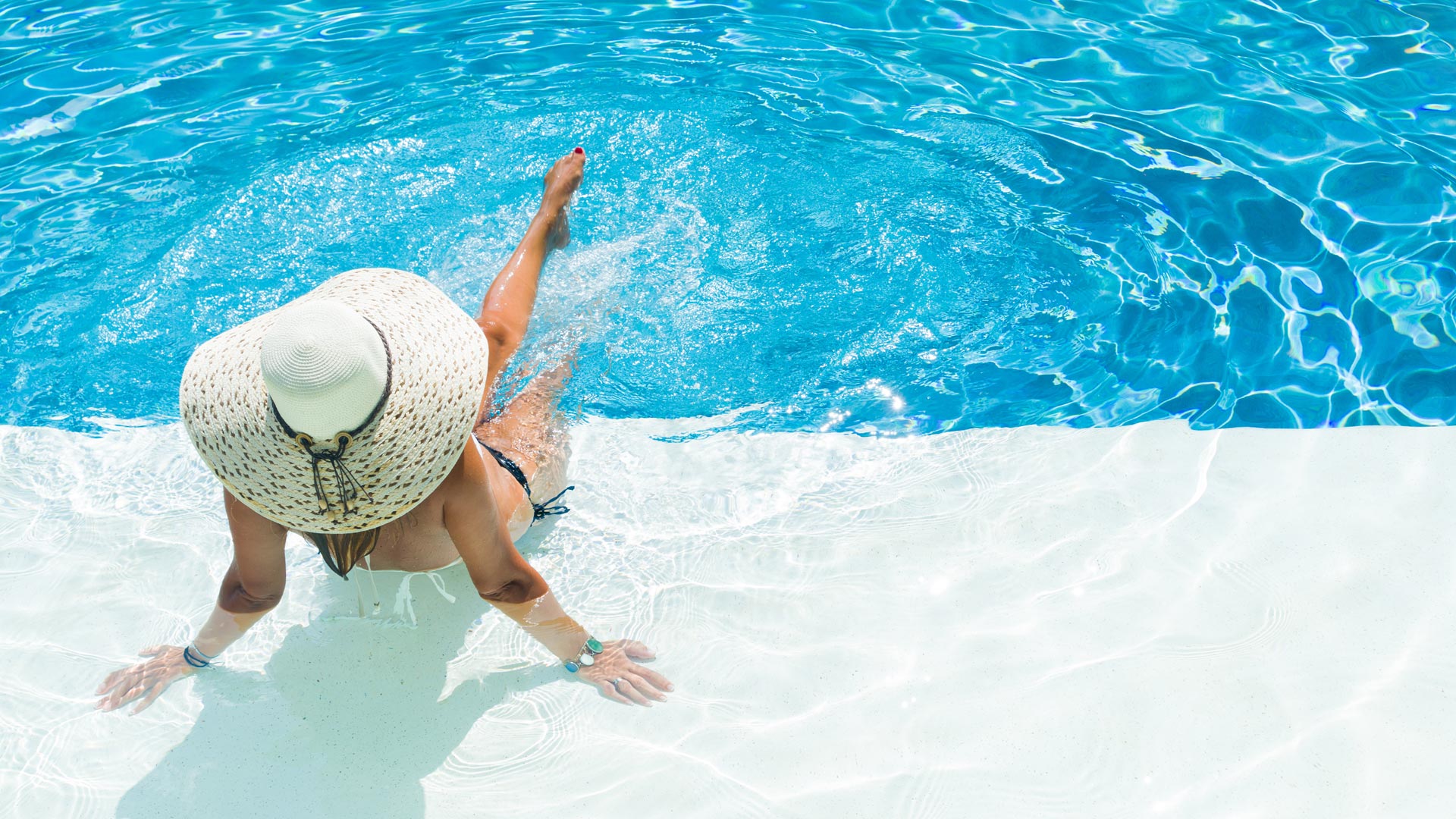 A woman enjoying her private pool in a Greek villa.